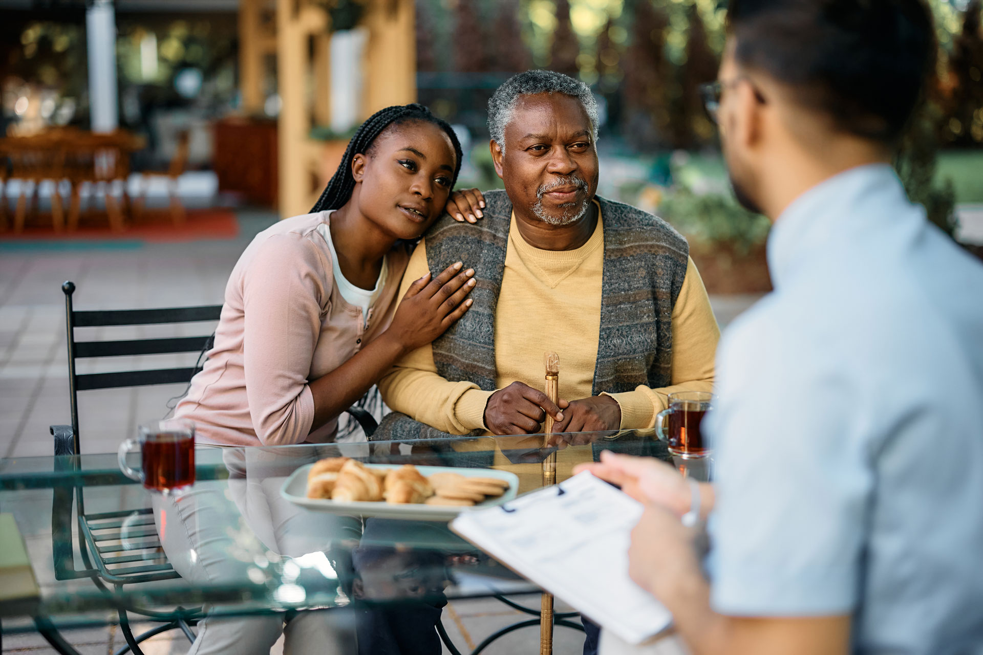 PLC_Financial-Resorces_What-This-Means_572805974_web A senior man sitting at an outdoor table with his granddaughter leaning his shoulder.